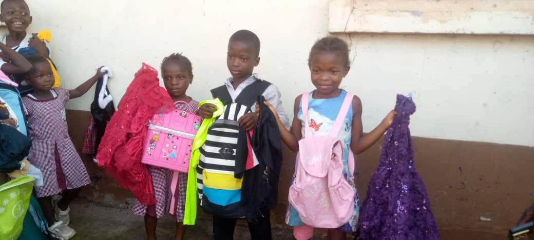 Children showing new backpacks and clothing
